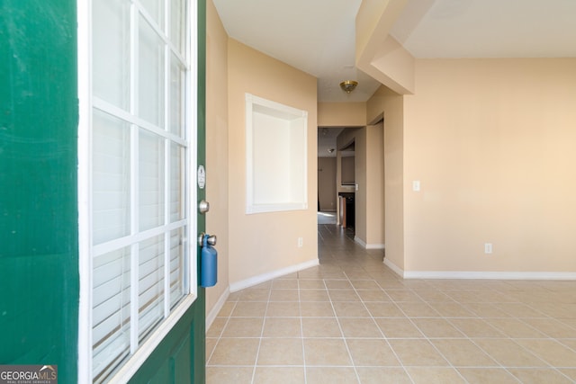 foyer entrance with light tile patterned floors and baseboards