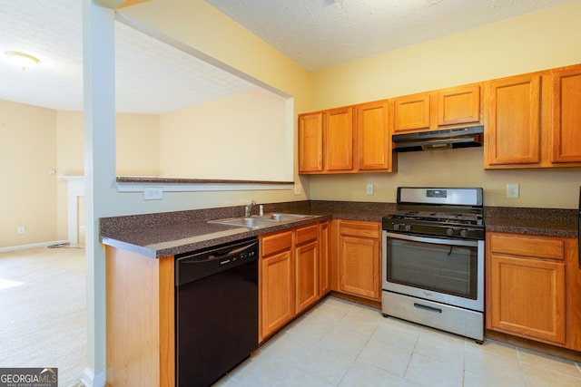 kitchen featuring dishwasher, dark countertops, stainless steel gas range, under cabinet range hood, and a sink