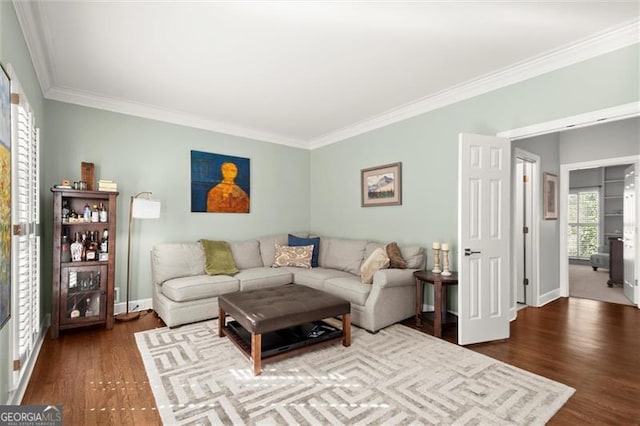 living room featuring ornamental molding, baseboards, and wood finished floors