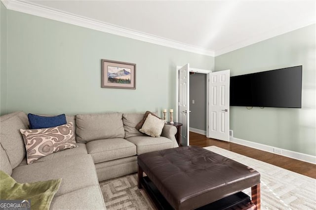 living area featuring ornamental molding, wood finished floors, and baseboards