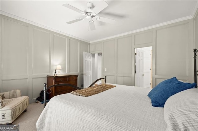 bedroom with a ceiling fan, a decorative wall, crown molding, and light colored carpet