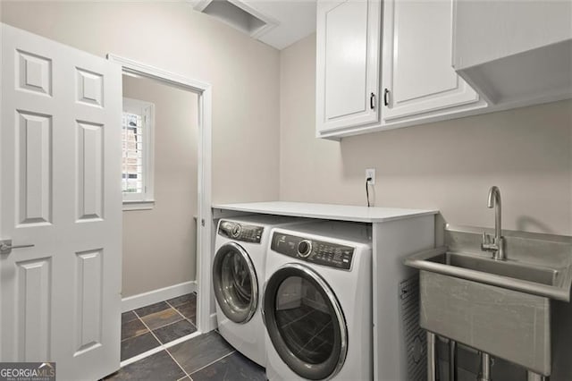 laundry room featuring baseboards, a sink, cabinet space, and washer and dryer