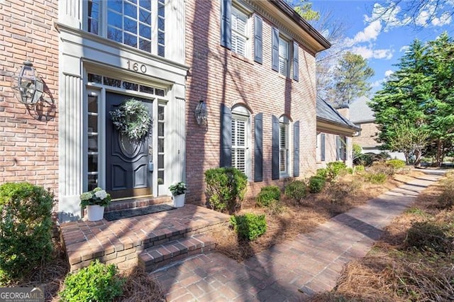 property entrance featuring brick siding