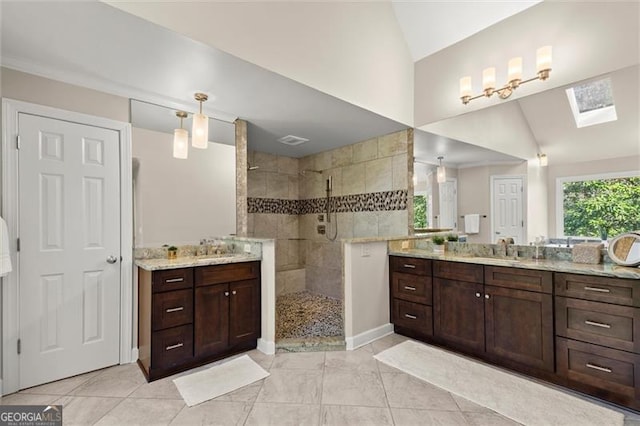 bathroom featuring lofted ceiling with skylight, two vanities, a sink, and a walk in shower