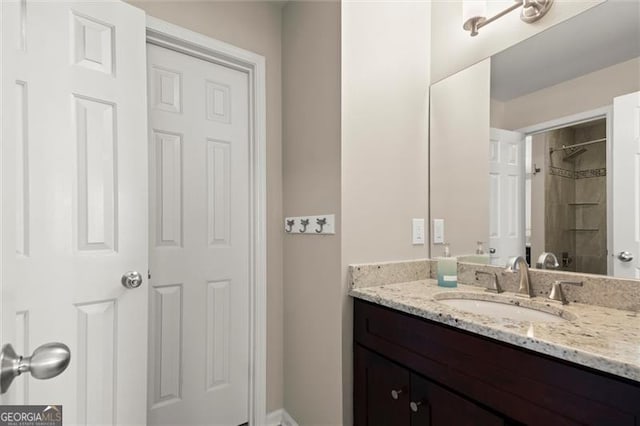 bathroom featuring a tile shower and vanity