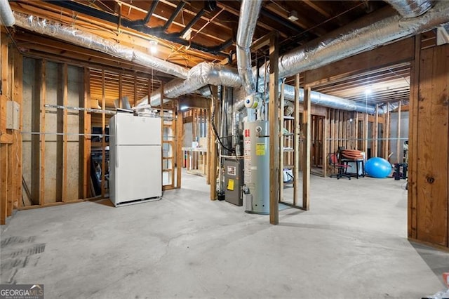 unfinished below grade area featuring water heater and freestanding refrigerator