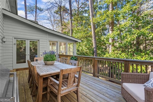 wooden deck featuring french doors and outdoor dining space