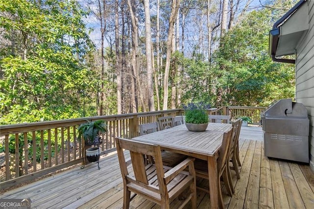 deck featuring outdoor dining space and a grill