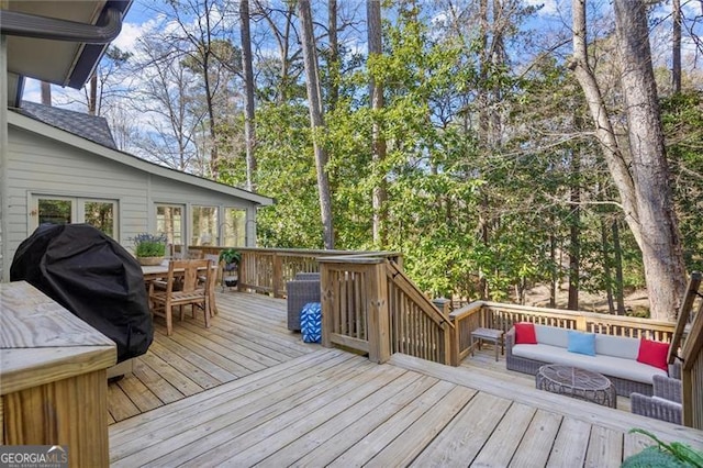 wooden deck with outdoor dining area, grilling area, and an outdoor hangout area