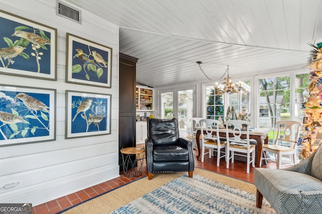 sunroom featuring a notable chandelier, wood ceiling, visible vents, and a wealth of natural light