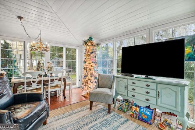 sunroom featuring lofted ceiling, wooden ceiling, and a notable chandelier