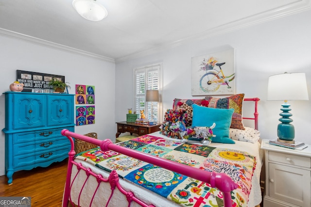 bedroom featuring ornamental molding and wood finished floors