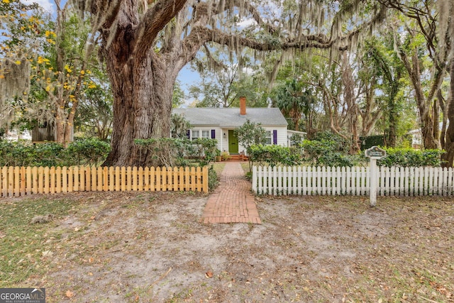 ranch-style house featuring a fenced front yard and a chimney