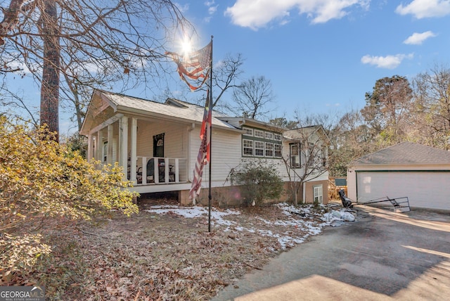 view of front of home featuring covered porch, an outbuilding, and a garage