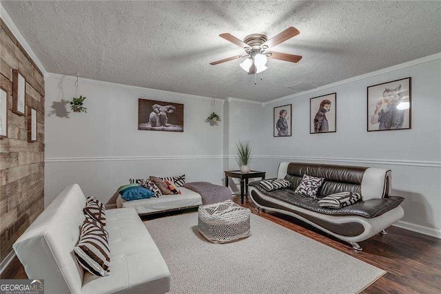 living area featuring a textured ceiling, wood finished floors, a ceiling fan, and crown molding