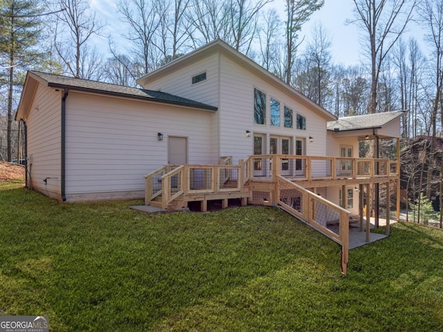 back of house featuring a deck, a yard, and stairs