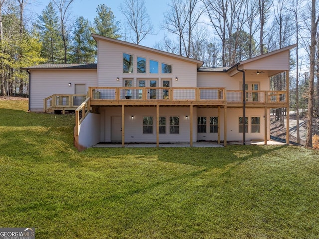 rear view of property with ceiling fan, a yard, a patio area, and a wooden deck