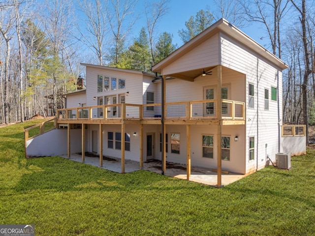 rear view of house featuring ceiling fan, a yard, cooling unit, a wooden deck, and a patio area