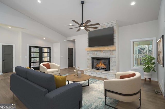 living area with baseboards, wood finished floors, vaulted ceiling, a fireplace, and recessed lighting