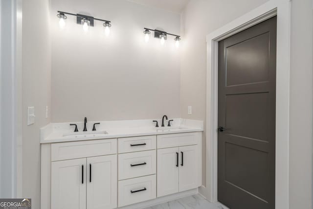 full bathroom with marble finish floor, double vanity, and a sink