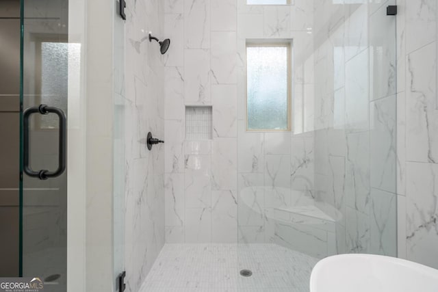 bathroom featuring a shower stall and a freestanding bath