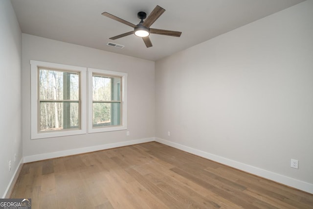 unfurnished room with visible vents, light wood-style flooring, and baseboards