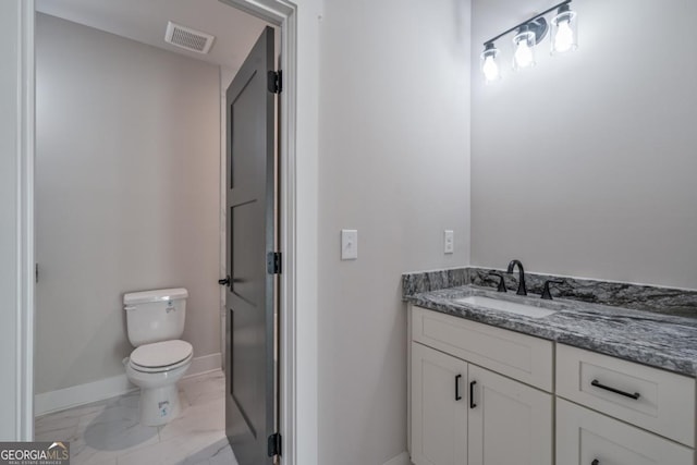 bathroom with toilet, vanity, visible vents, baseboards, and marble finish floor