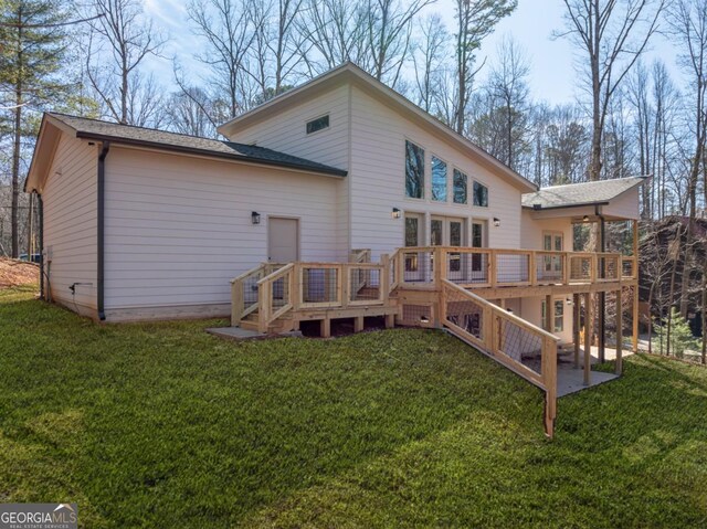 view of front facade with an attached garage, driveway, stone siding, french doors, and a front lawn