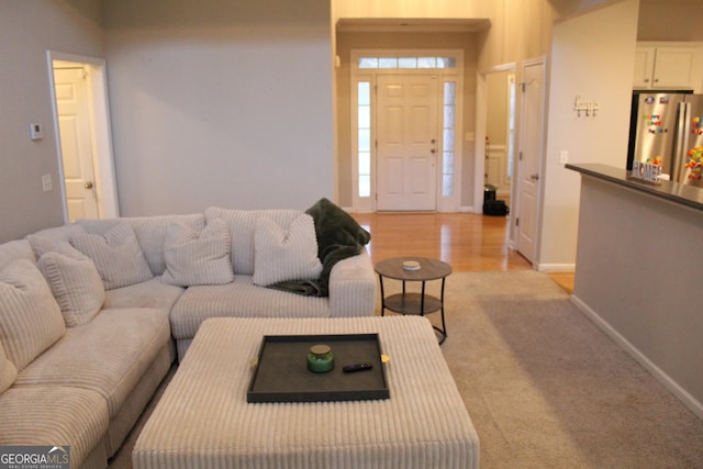 living area with light wood-type flooring and baseboards