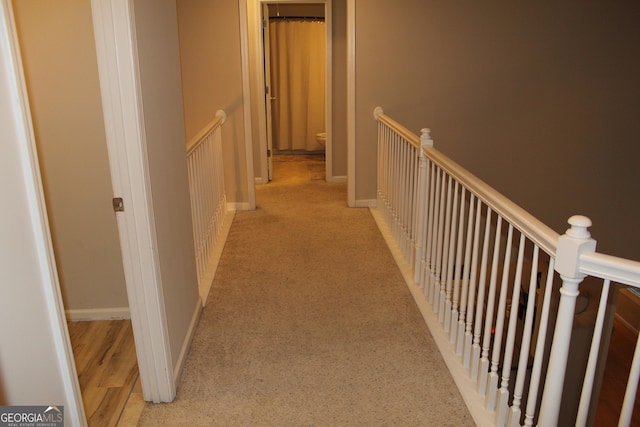 hall with baseboards and an upstairs landing