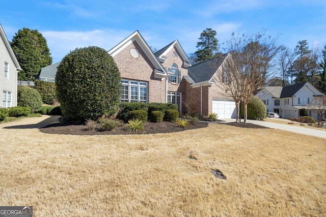 traditional-style house with driveway, brick siding, and a front yard