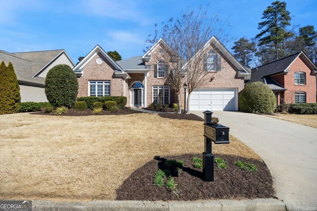 traditional-style house featuring an attached garage, a front yard, concrete driveway, and brick siding