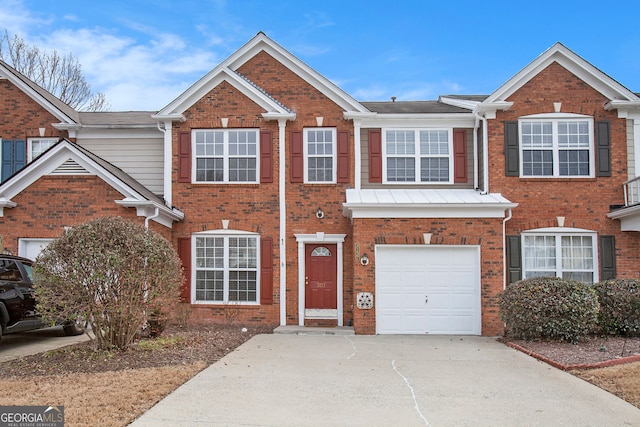 multi unit property with concrete driveway, brick siding, and an attached garage