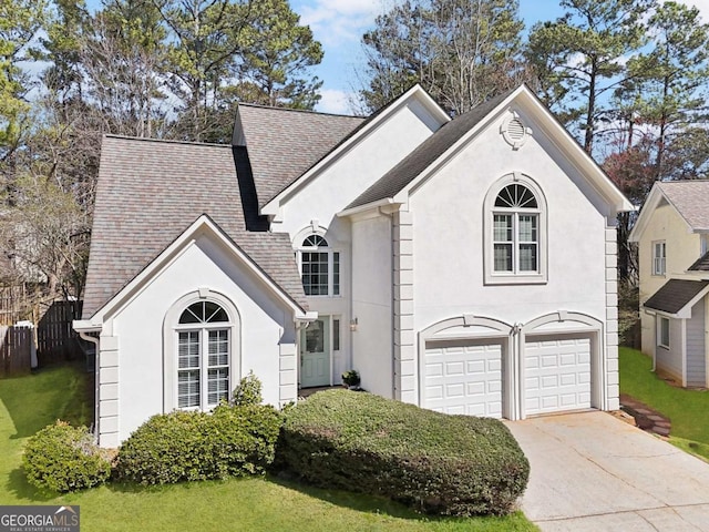 view of front of home featuring an attached garage, a shingled roof, driveway, stucco siding, and a front yard