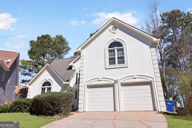 view of front of property with concrete driveway, roof with shingles, an attached garage, and stucco siding