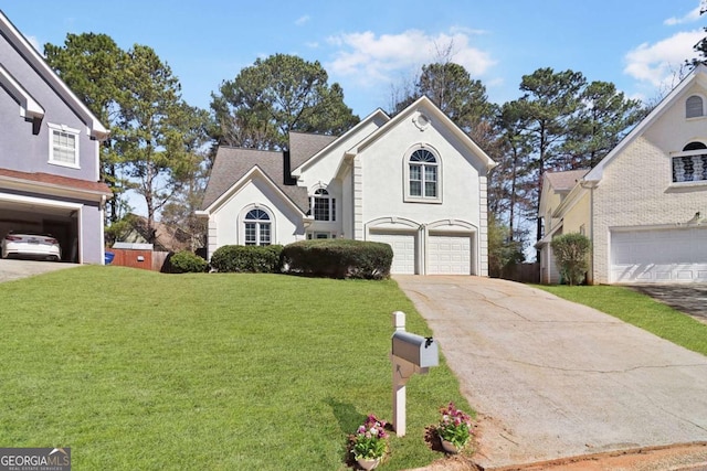 traditional-style home featuring an attached garage, a front lawn, concrete driveway, and stucco siding