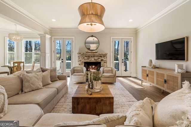 living room with ornamental molding, french doors, a fireplace, and wood finished floors