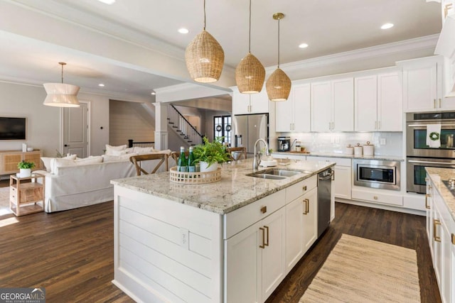 kitchen with open floor plan, dark wood-style flooring, stainless steel appliances, crown molding, and a sink