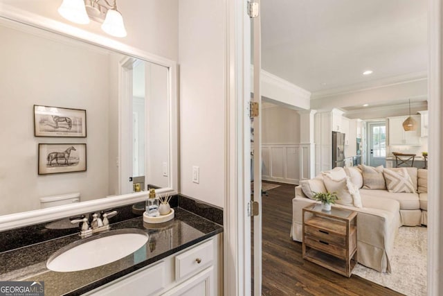 bathroom with a wainscoted wall, toilet, ornamental molding, wood finished floors, and ornate columns