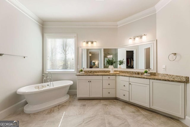 bathroom featuring a sink, baseboards, ornamental molding, a soaking tub, and double vanity