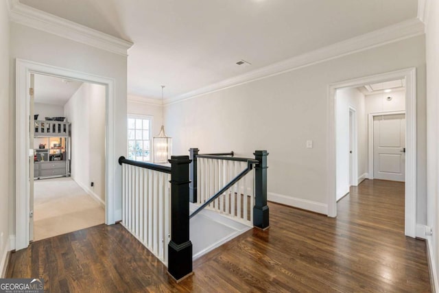 hall featuring attic access, ornamental molding, an upstairs landing, and wood finished floors