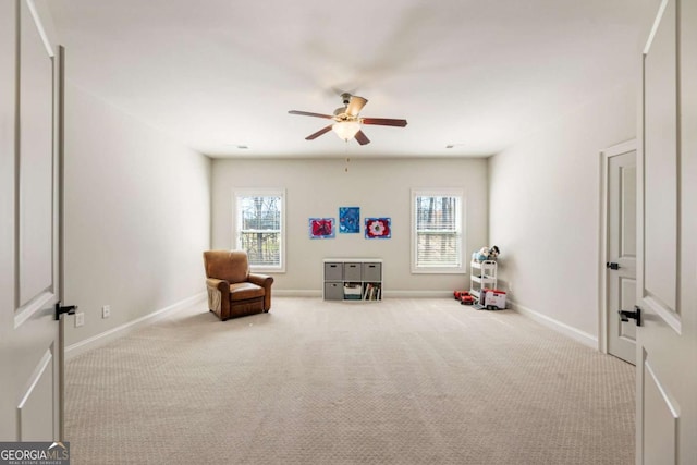 living area featuring carpet floors, ceiling fan, and baseboards