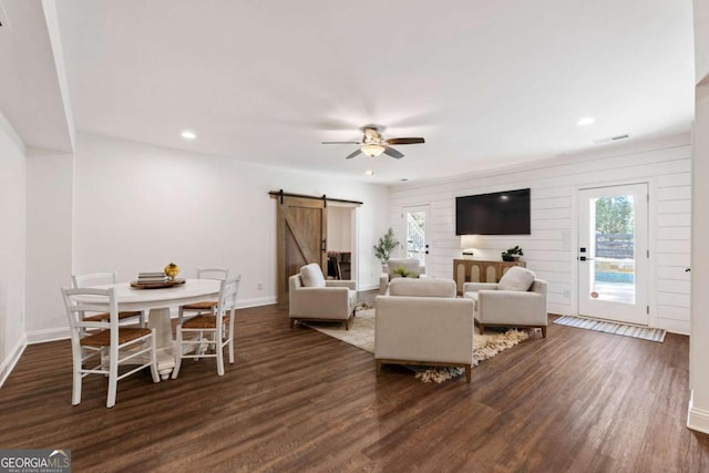 living room with recessed lighting, a barn door, dark wood-type flooring, a ceiling fan, and baseboards