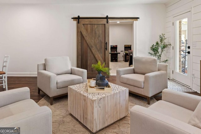 living area featuring baseboards, light wood finished floors, and a barn door