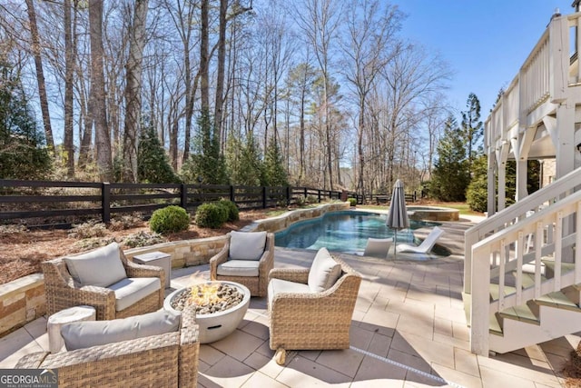 view of swimming pool featuring a patio, fence, an outdoor living space with a fire pit, and a fenced in pool