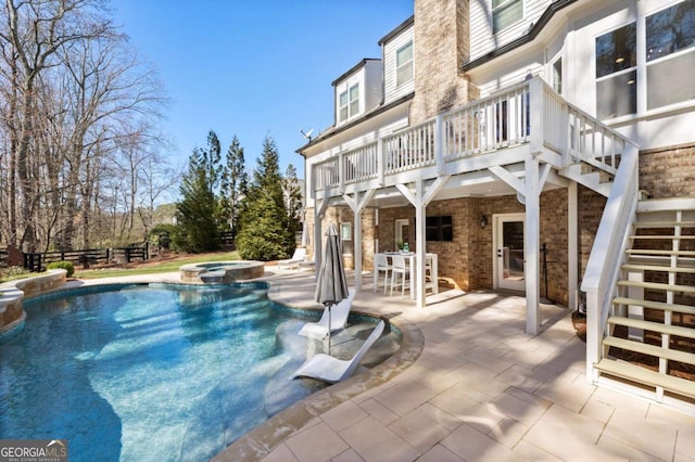 view of pool featuring a patio area, a pool with connected hot tub, and stairway