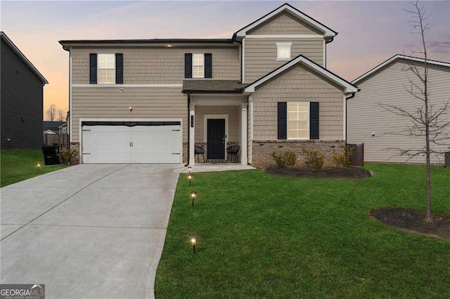 view of front of home featuring driveway, stone siding, a garage, and a front lawn