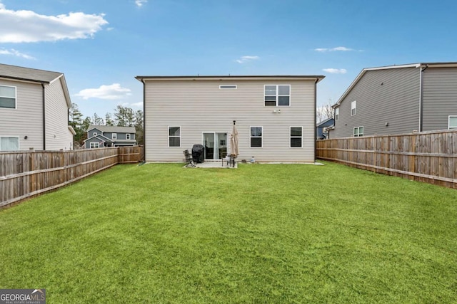 back of property featuring a fenced backyard and a lawn