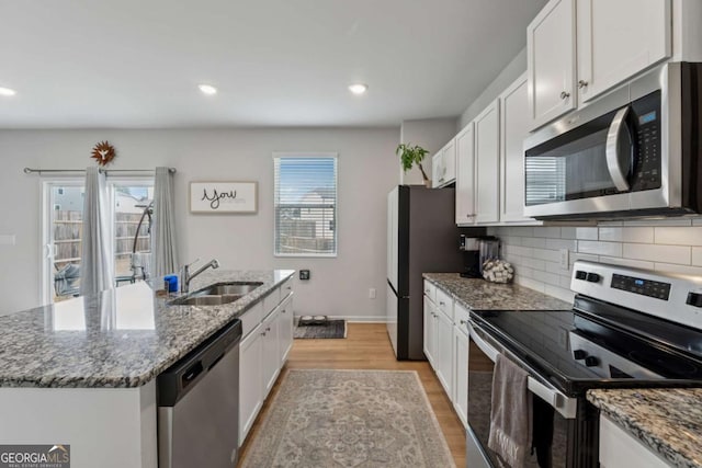 kitchen featuring appliances with stainless steel finishes, white cabinets, and a sink