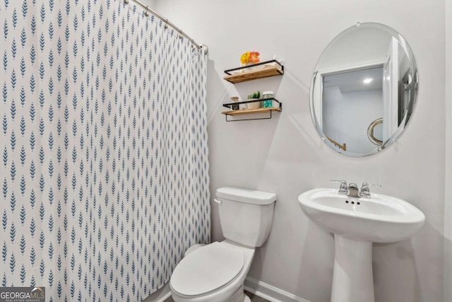 full bathroom featuring toilet, a shower with curtain, and baseboards